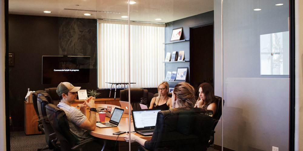 Meeting room with three people pitching to the CFO