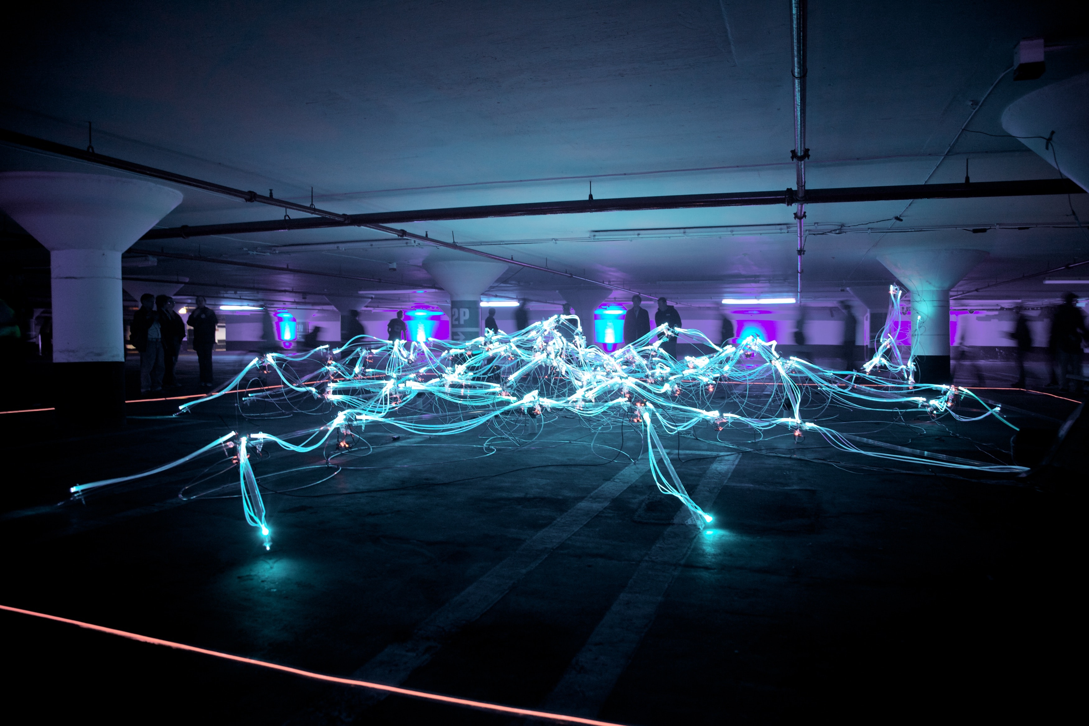 four people in the Car park connecting electricity together 