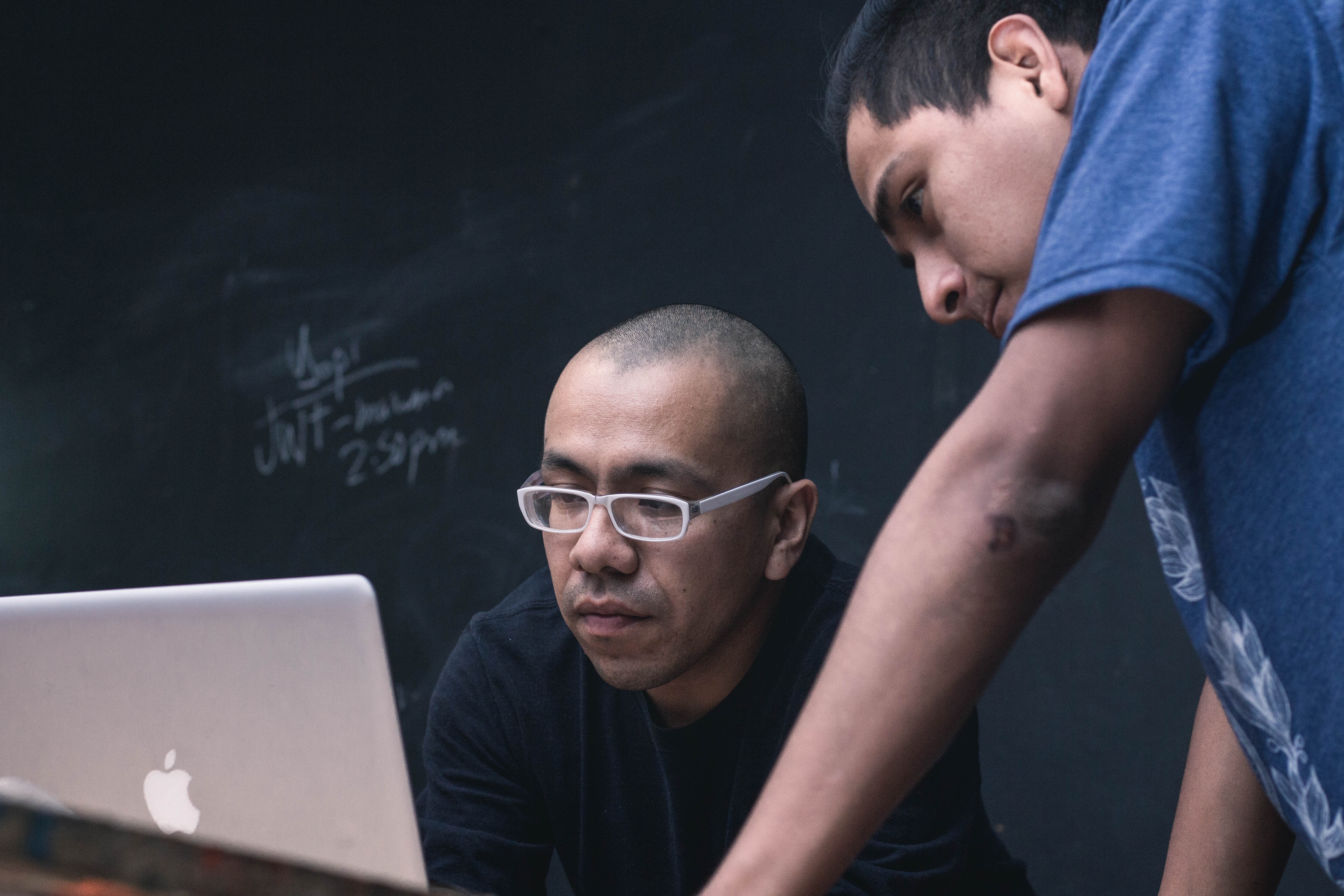 a NetSuite professional teaching another on his laptop. 